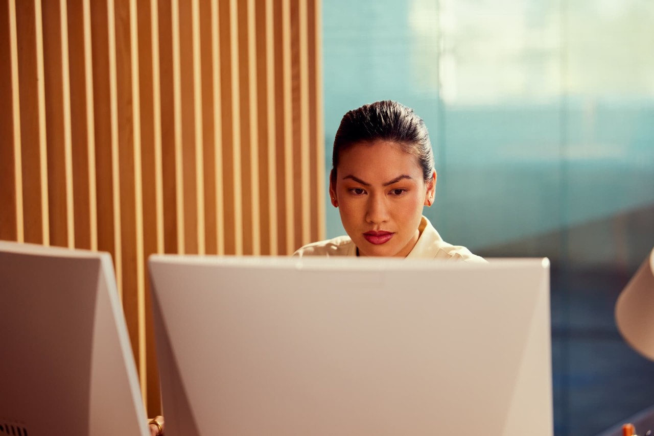 Female analyst, front view, sitting in front of computer screens